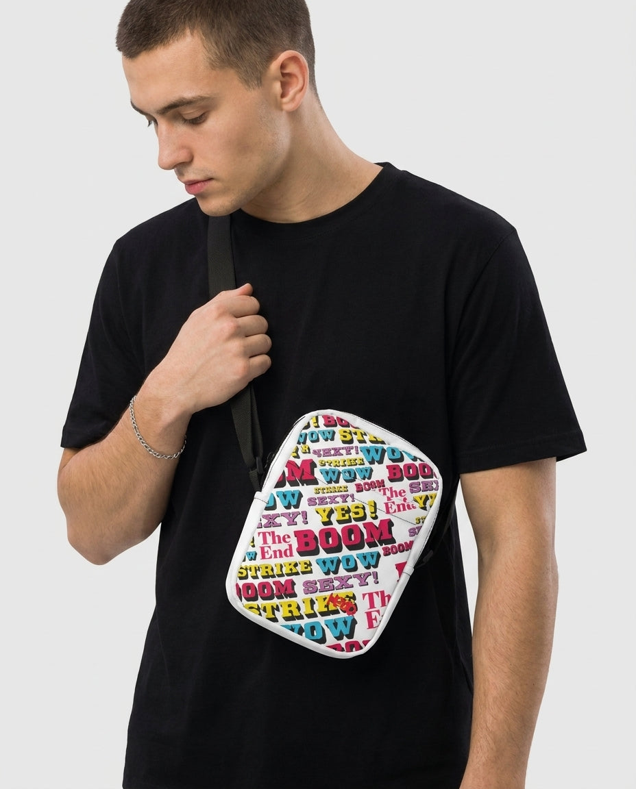 Man wearing the Strike utility crossbody bag by Design Hero, comic pop art all-over print, studio photo