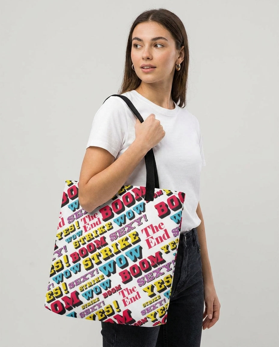 Woman carrying the Strike large tote bag by Design Hero, comic pop art all-over print, studio photo