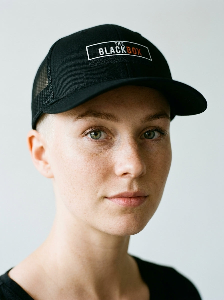The Black Box Trucker Cap worn by a model